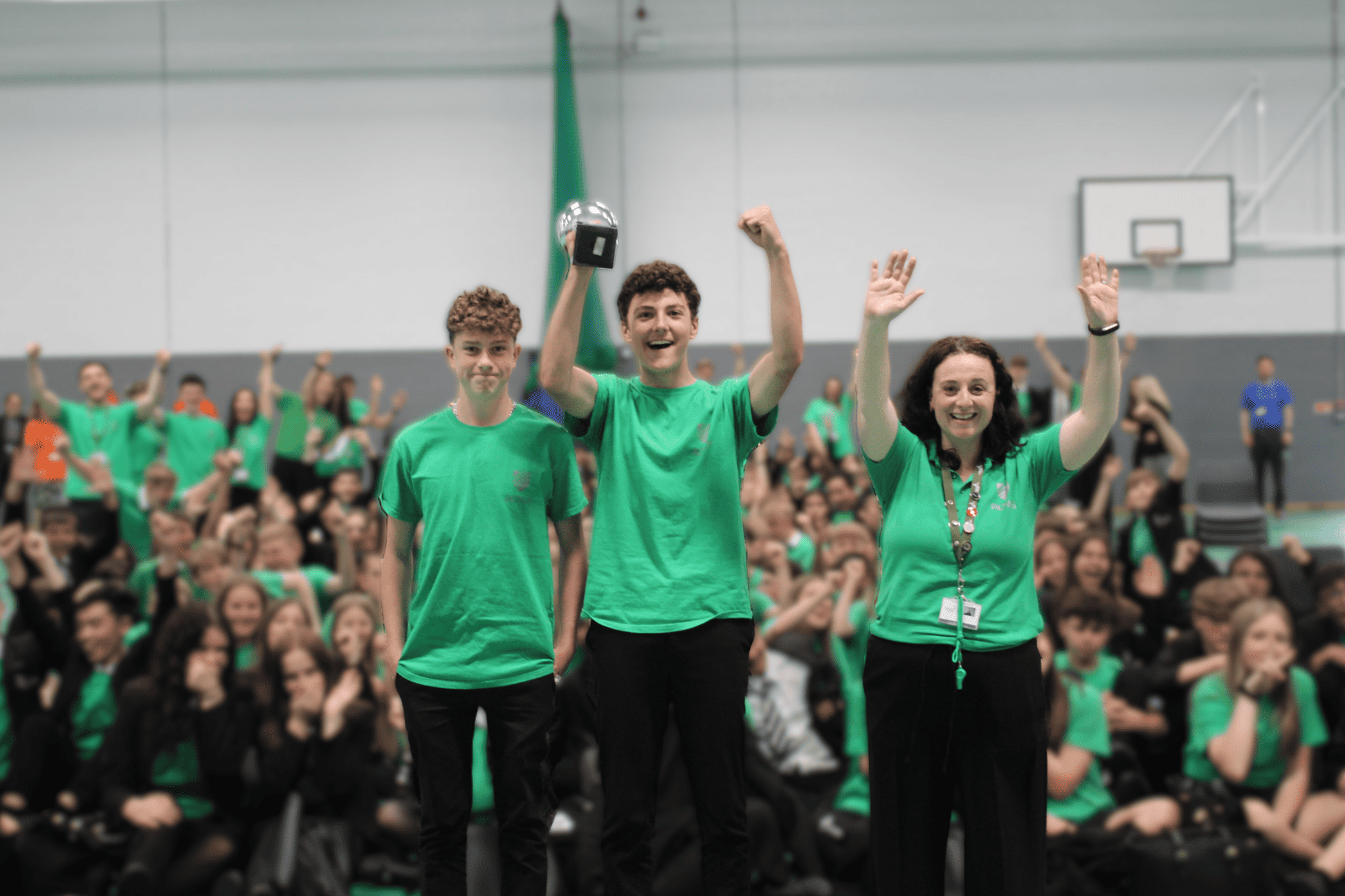 The winners of the Sports Cup, Altius, hold the trophy smiling in Cheadle Hulme High School sports hall