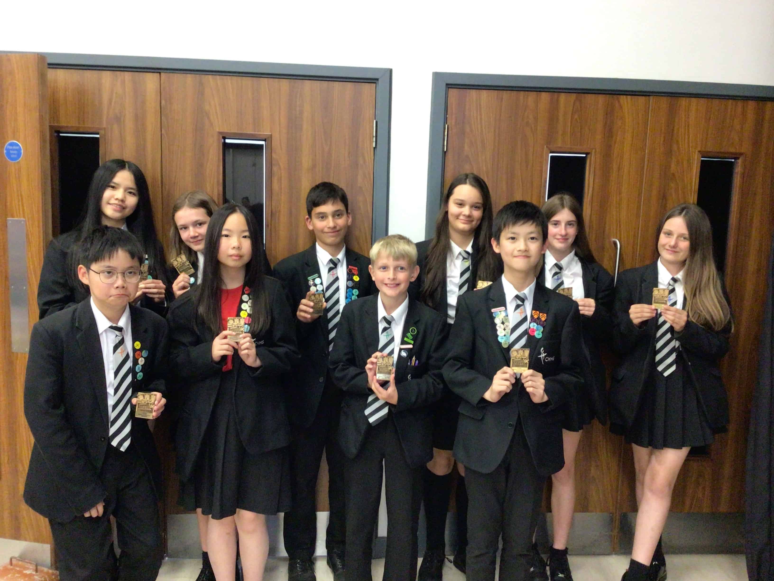 CHHS students smile with their Maths Award magnets that they earned at the Cheadle Hulme High School Maths Award Evening.