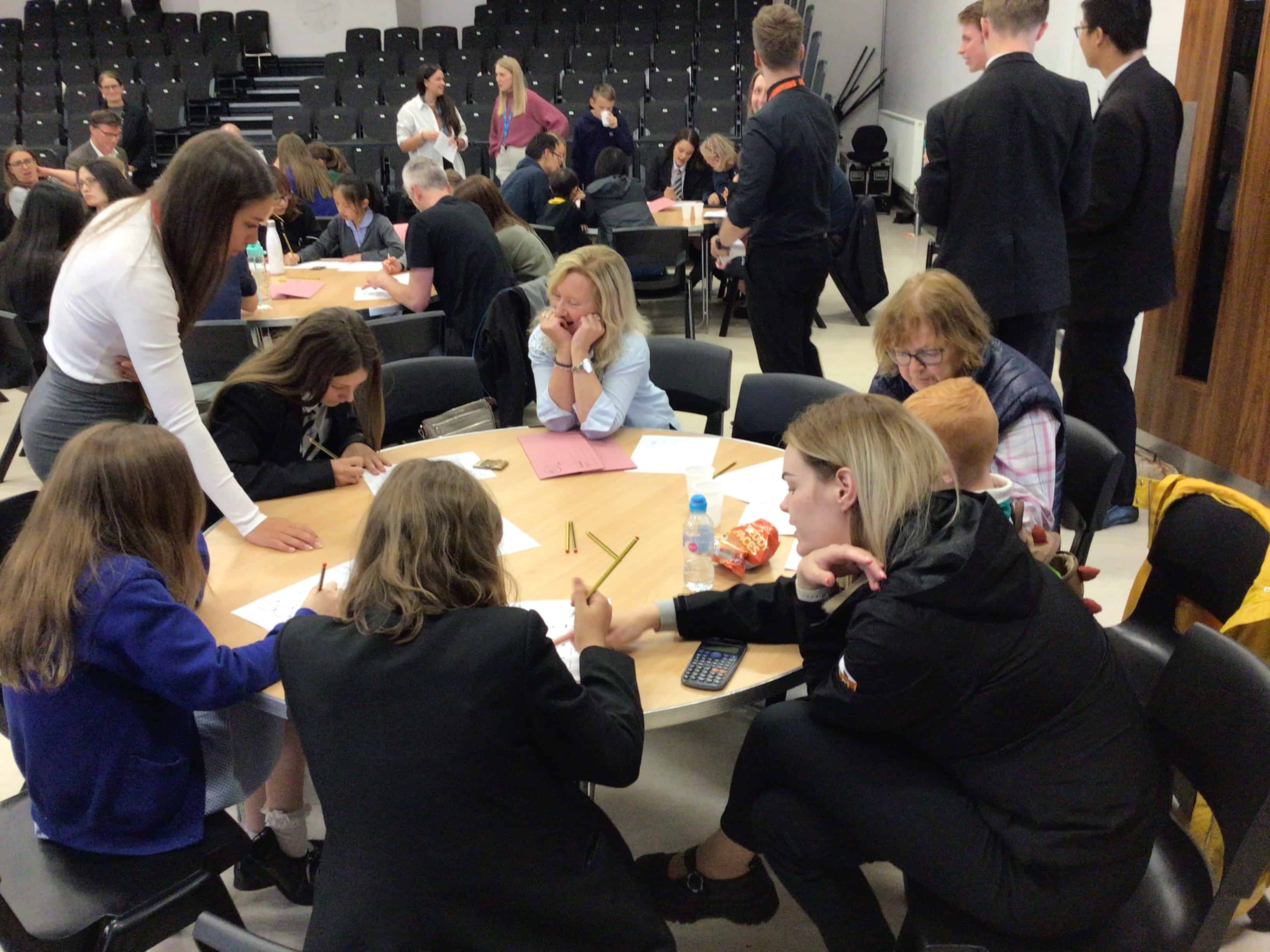 Pupils, parents and teachers working together to solve maths problems at Cheadle Hulme High School Maths Awards evening