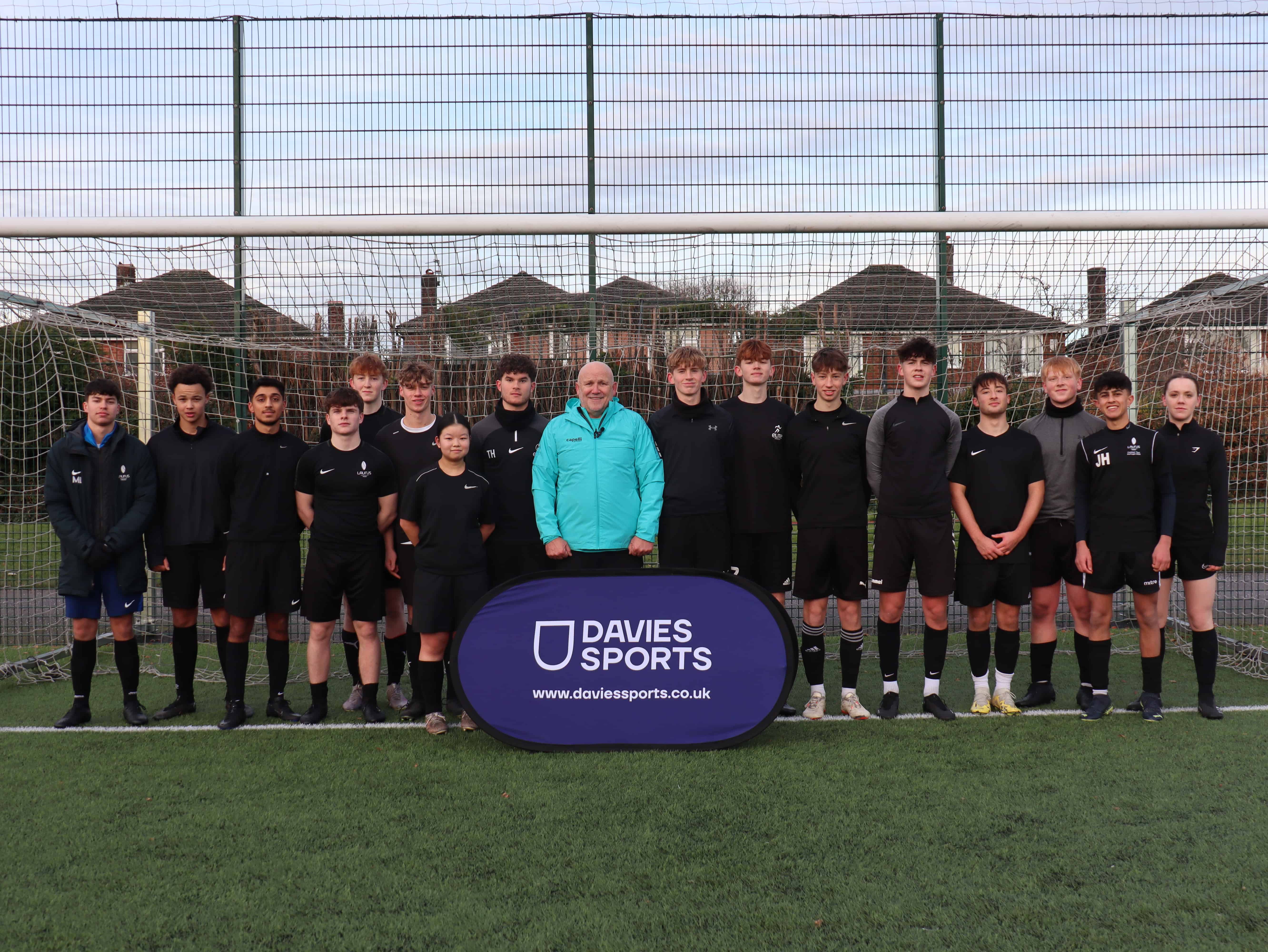 Mike Phelan stands with Cheadle Hulme Sixth Form students.