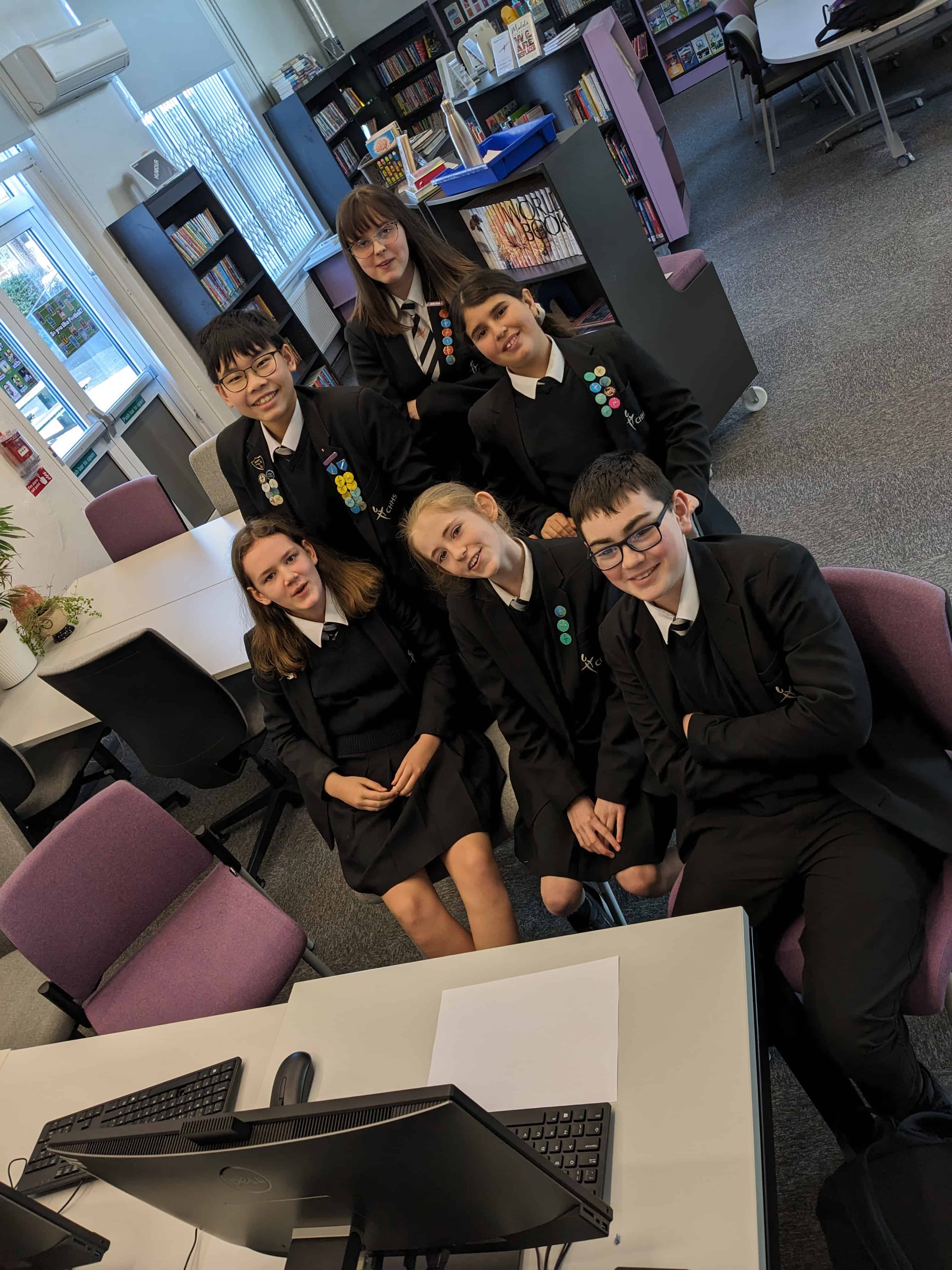 The Cheadle Hulme High School team and scribes for the National Reading Champions Quiz 2024 sit together in the school library.