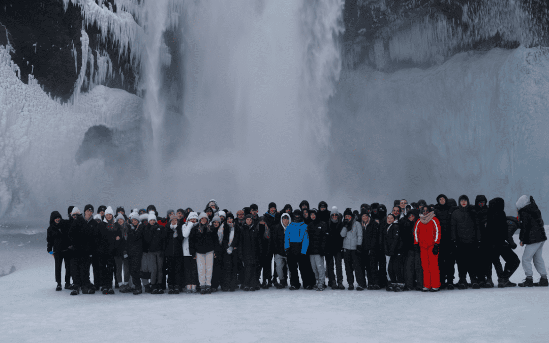 Students from Cheadle Hulme High School stand in front of Skógafoss waterfall in Iceland.